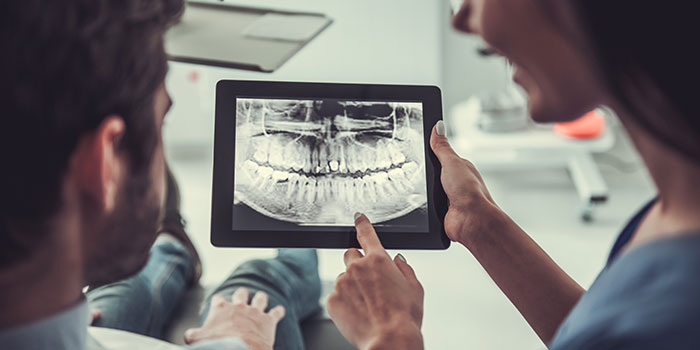 dentist showing patient digital image on ipad
